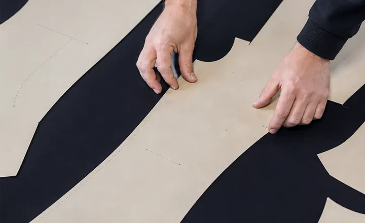 Wetsuit pattern pieces arranged on black neoprene material