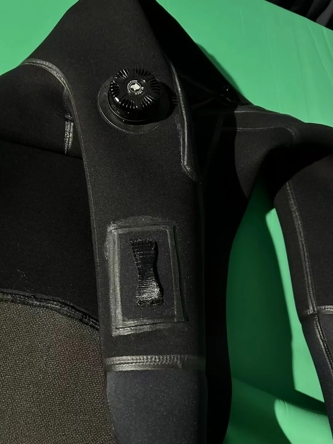 Black Smooth Finish Suit with Reinforced Panels, valve detail.