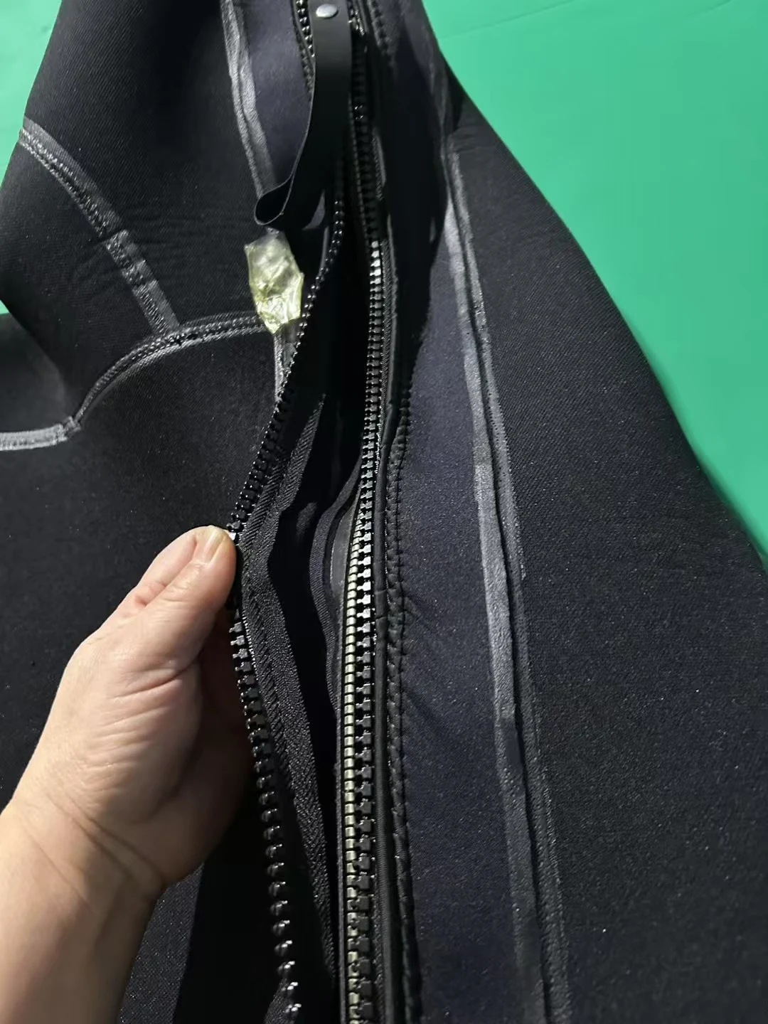 Black Smooth Finish Suit with Reinforced Panels, zipper opening detail.