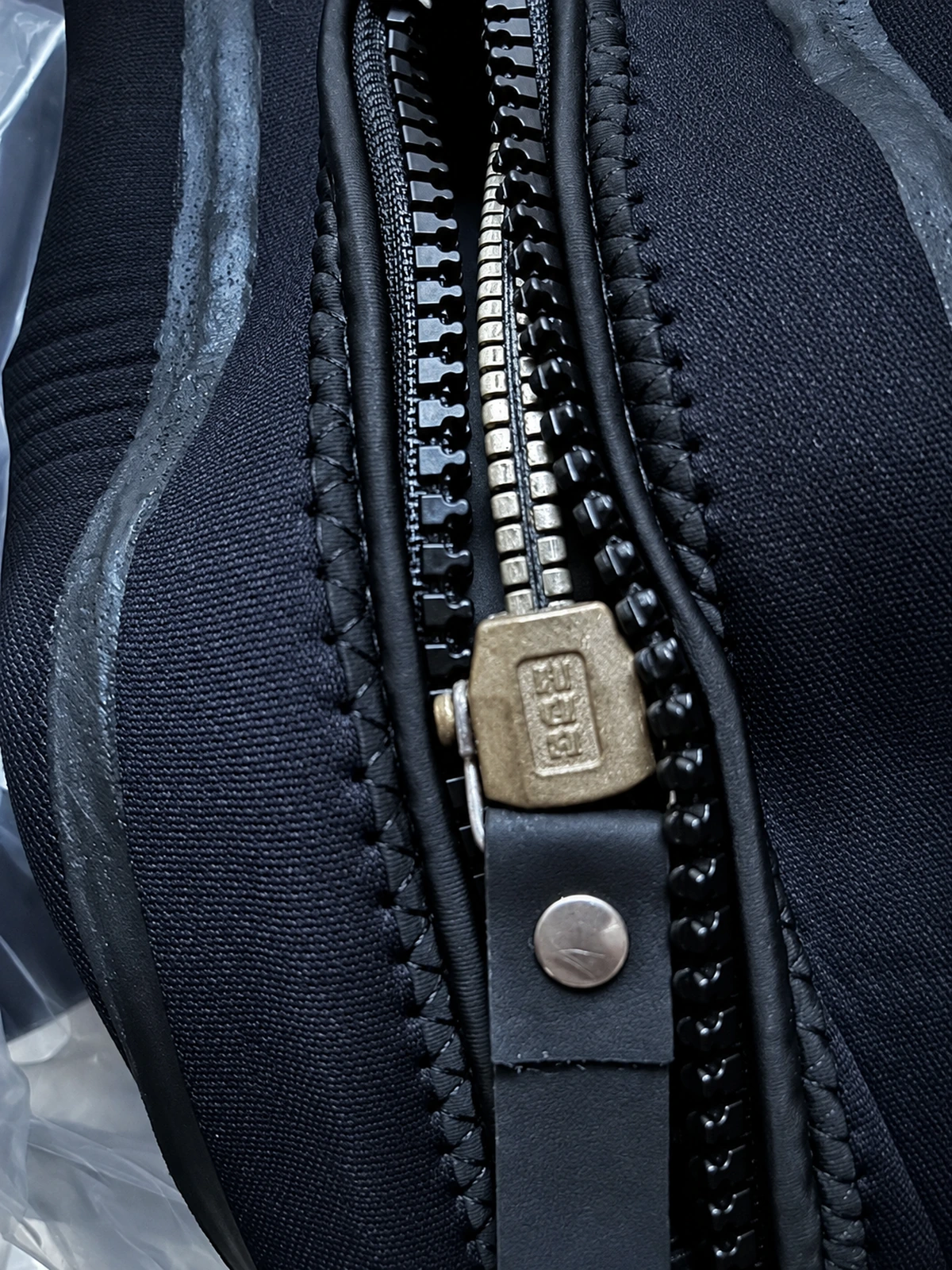 Black Smooth Finish Suit with Reinforced Panels, zipper slider detail.