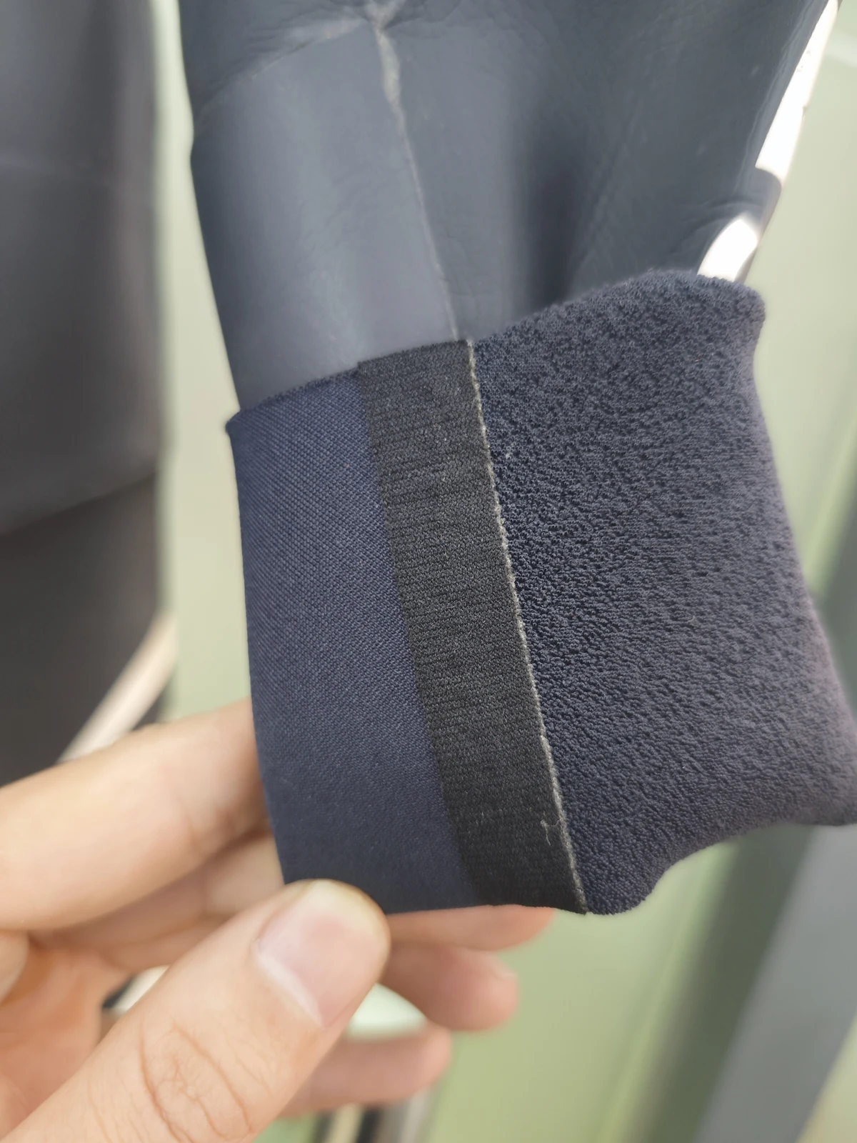 A folded cuff showing the inner fabric and joining strip. Detail of the INSEAKU blue accent triathlon wetsuit.
