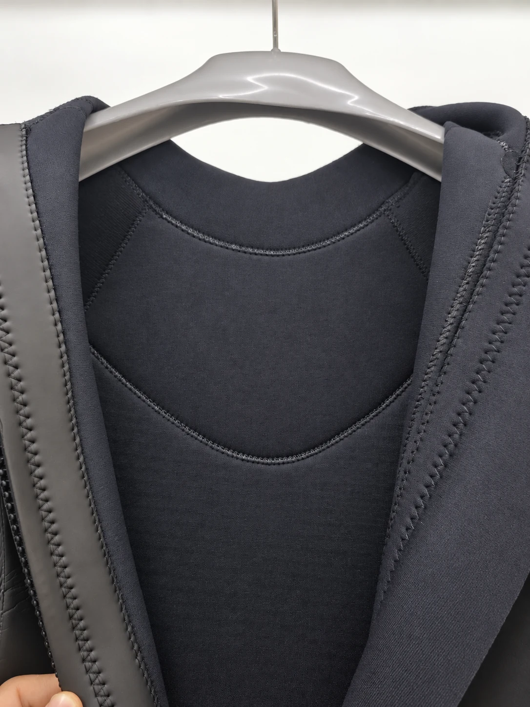 Black inner neck lining and curved seams. Detail of the INSEAKU blue accent triathlon wetsuit.