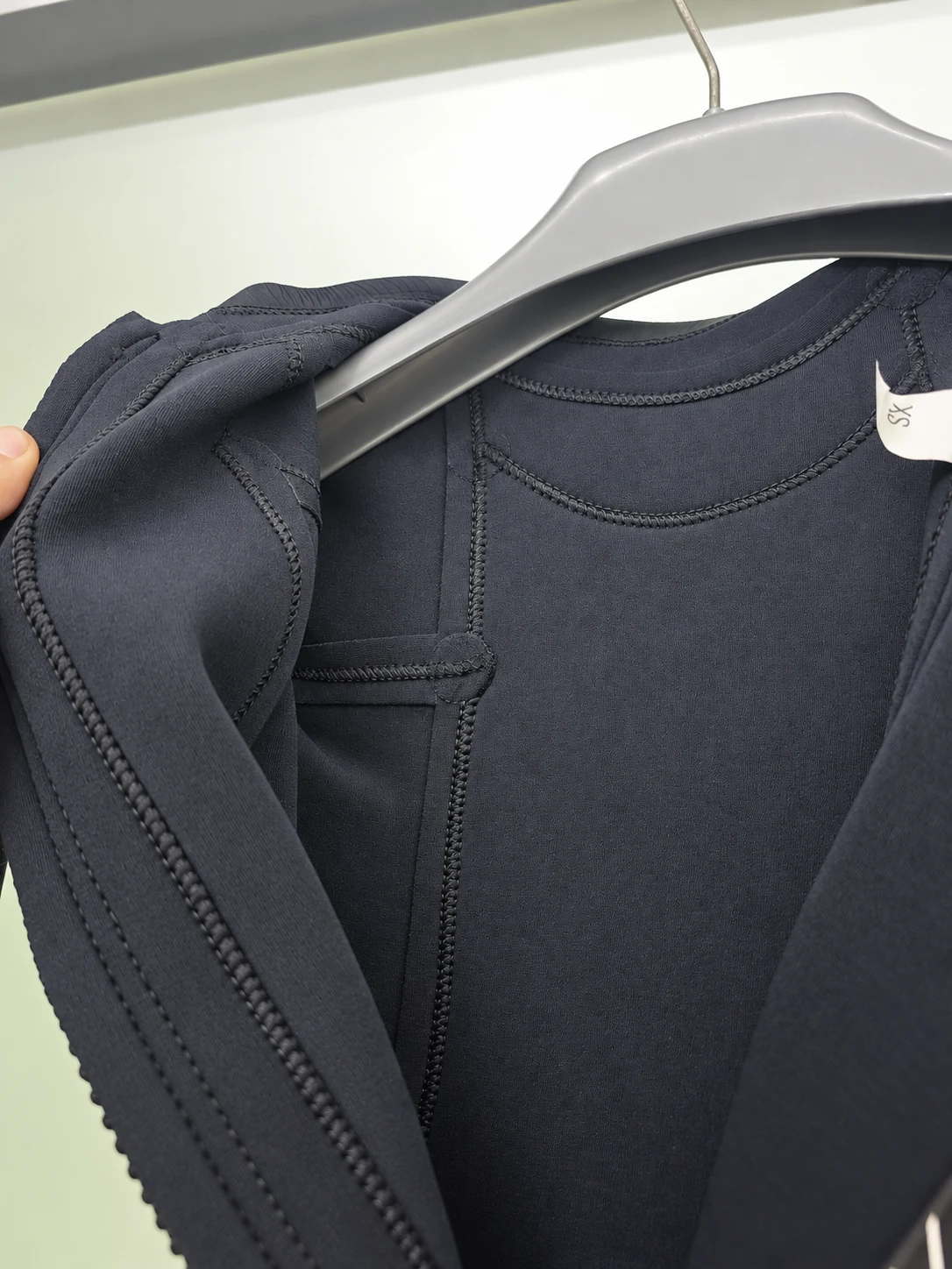 Curved stitching on the inner neck lining. Detail of the INSEAKU minimal black back zip triathlon wetsuit.