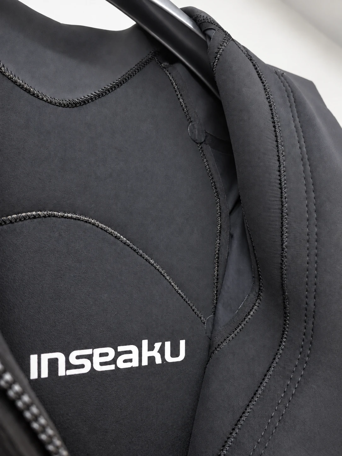 Inner neckline and curved lining seams. Detail of the INSEAKU orange chevron triathlon wetsuit.