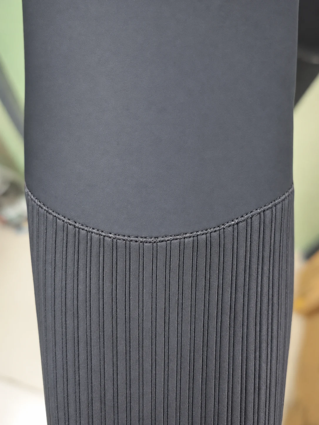 Vertical ribbed texture on the forearm panel. Detail of the INSEAKU orange chevron triathlon wetsuit.