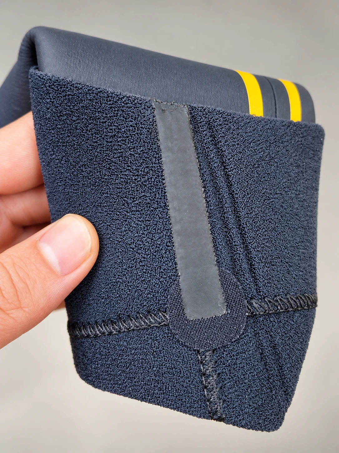 A folded cuff with visible inner joining strip. Detail of the INSEAKU yellow outline triathlon wetsuit.