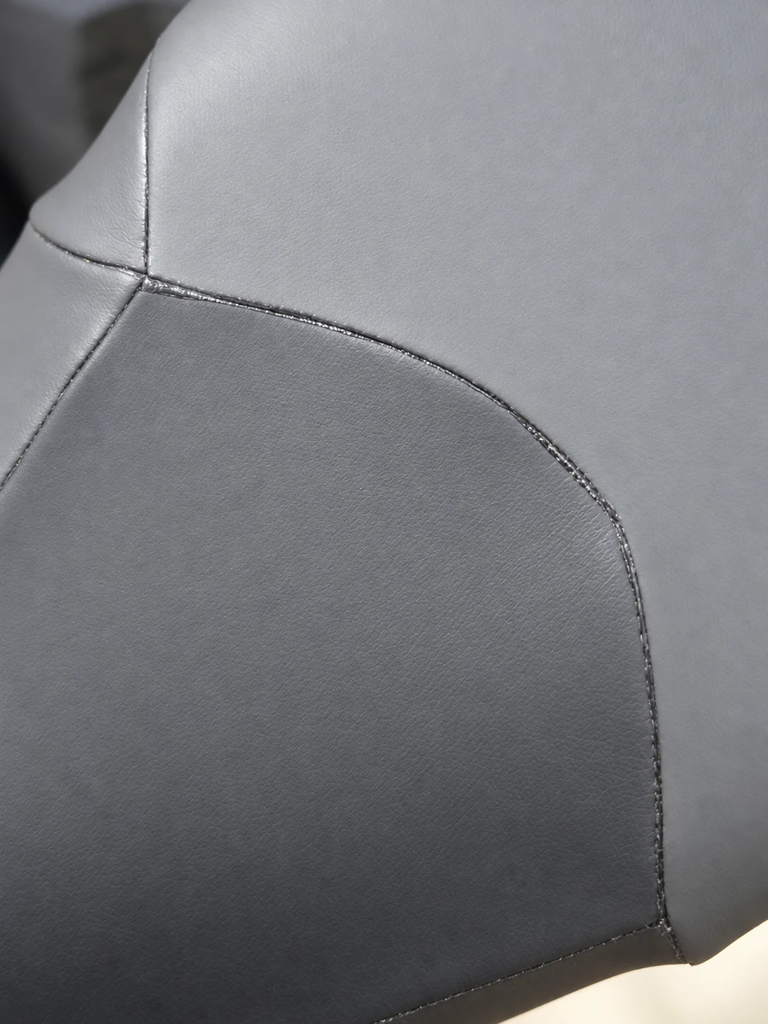 Curved upper panel seam on smooth black material. Detail of the INSEAKU yellow stripe triathlon wetsuit.